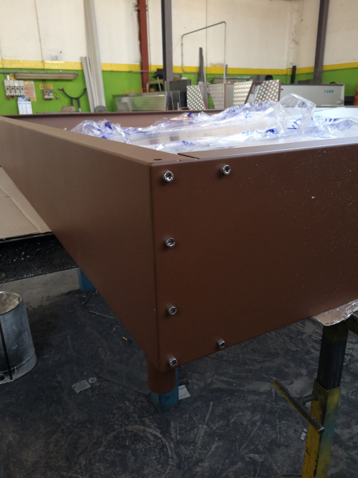 Elemento d'arredo in metallo bruno con fissaggi a vista