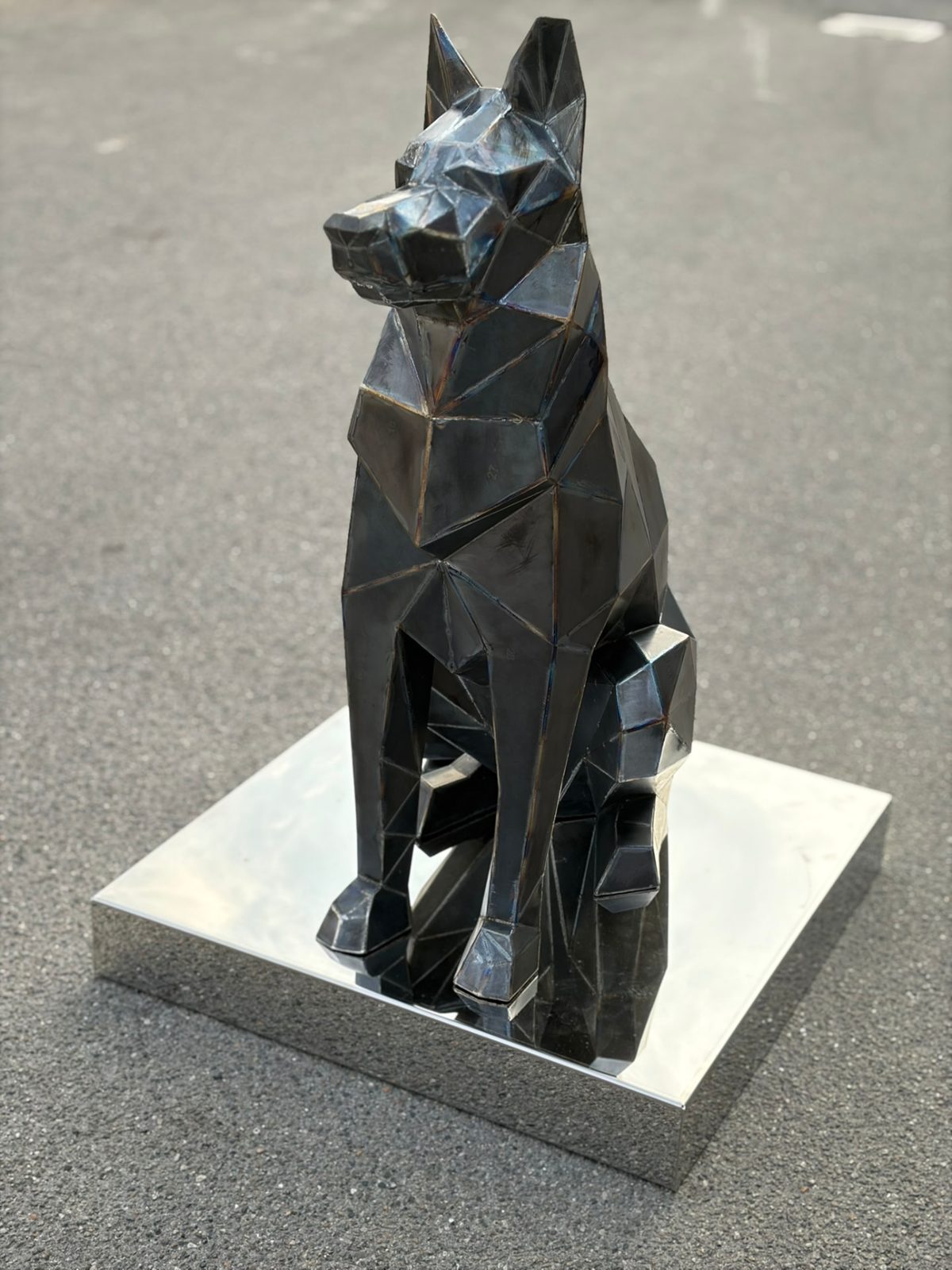 Scultura poligonale di cane in ferro brunito su base inox